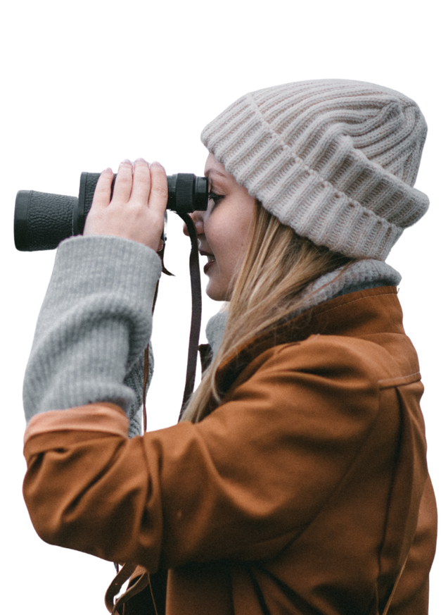 Eine junge Frau die durch ein Fernglas schaut